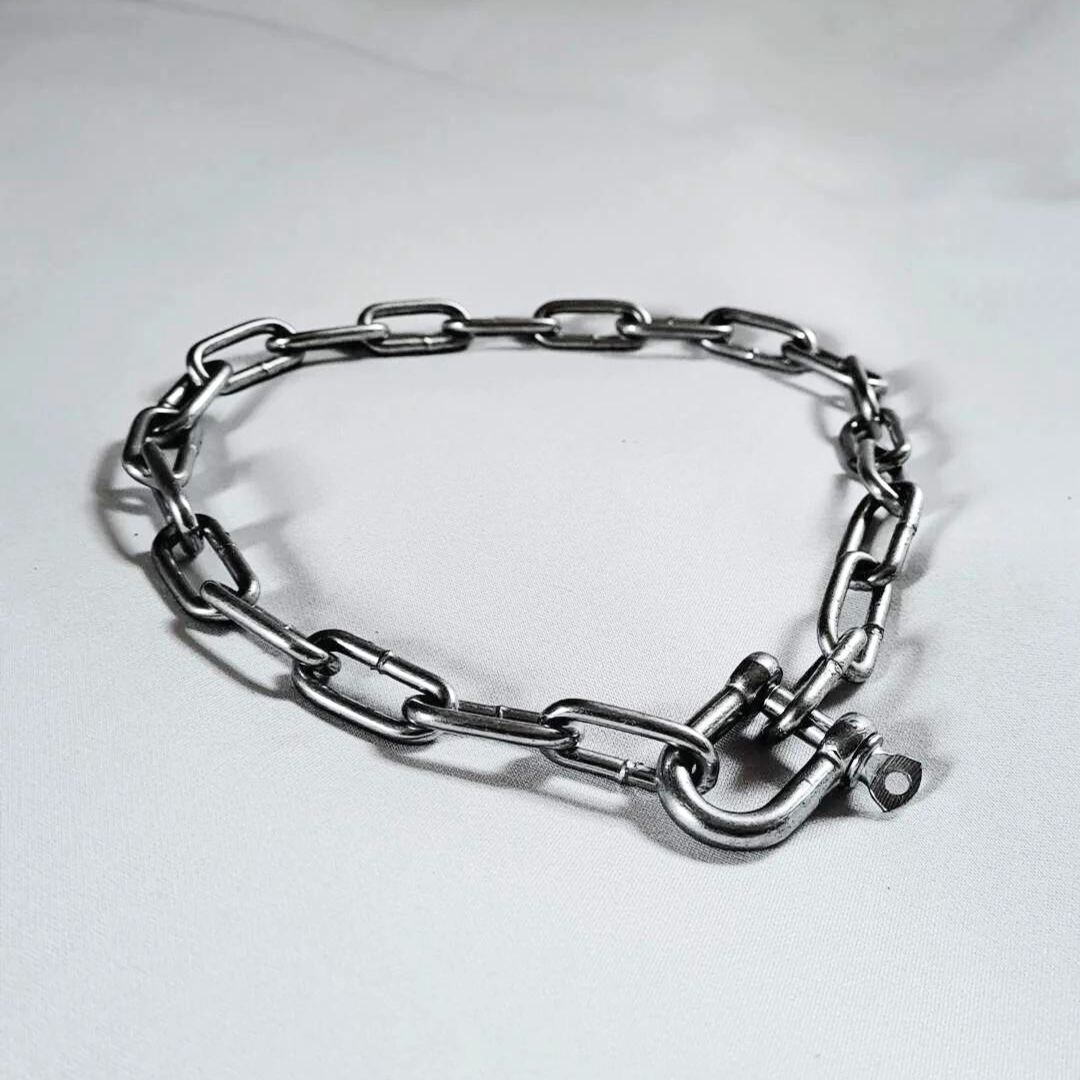 A silver stainless steel chain choker laid out on a white background.