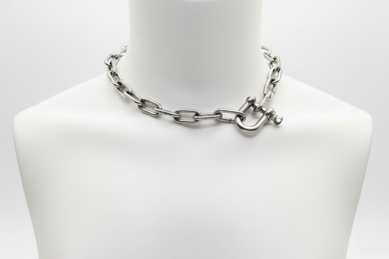 Silver chain necklace on a mannequin bust against a white background