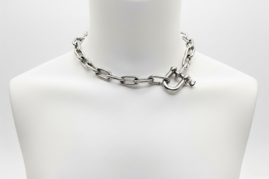 Silver chain necklace on a mannequin bust against a white background