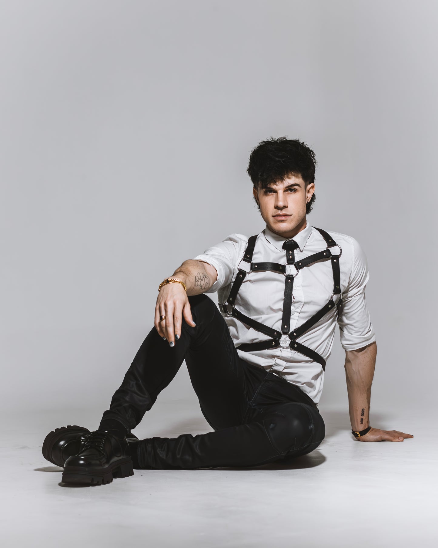 Man wearing a harness sitting on a white background